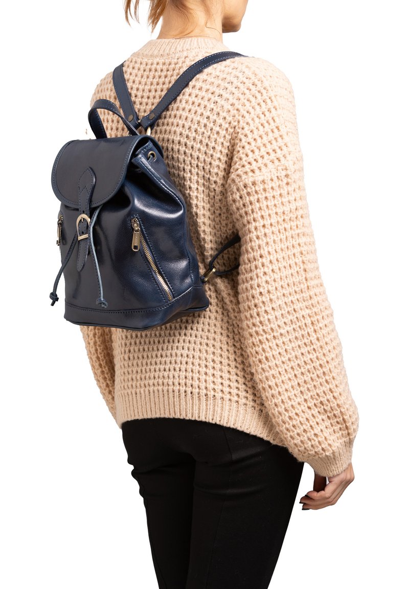 Navy leren rugzak met een trekkoordsluiting, voorflap en twee ritszakken. Voorzien van verstelbare schouderbanden en een zachte textuur.