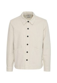 Veste en coton beige avec un col structuré, une fermeture avant à boutons, deux grandes poches et des boutons noirs pour le contraste.