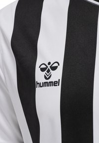 Zwart-wit gestreepte sporttrui van synthetische stof, met een ronde hals en het "hummel" logo in het zwart gedrukt.