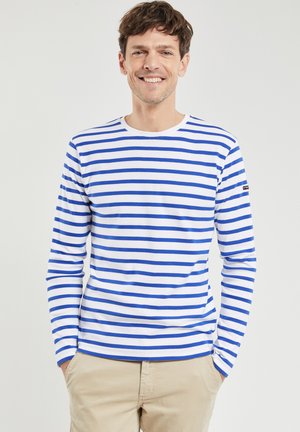 Langærmet skjorte med vandrette blå og hvide striber, rund halsudskæring, lavet af blødt stof, med et logo på venstre ærme.