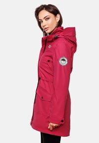 Roze waterdichte jas met een aantrekkoord in de taille, capuchon en zijzakken. Heeft een logo-opdruk op de mouw en een gladde, glanzende textuur.