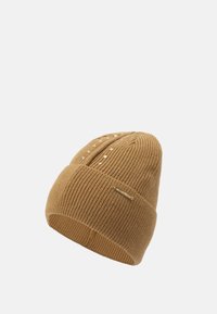 Brun strikket hue med ribbet struktur, med opbukket kant og lille dekorativ metalmærke på siden.