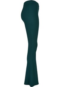 Geribbelde flared broek in diep groen, met een strakke pasvorm, elastische tailleband en gestructureerde stof voor extra detail.