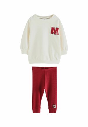 Cremfarbener Pullover-Sweatshirt mit rotem "M"-Logo, kombiniert mit roten Leggings. Weiches Material, lässige Passform, gerippte Bündchen und strukturierte Details.