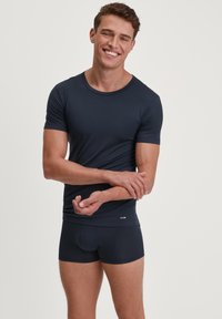Marineblauwe korte mouwen t-shirt en bijpassende boxershorts, gladde textuur, slank ontwerp, logo op de tailleband, subtiele halslijn.