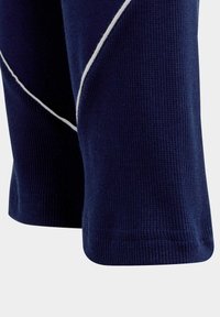 Marineblauwe geribde stof met korte mouwen shirt met diagonale witte bies. Glad textuur met een aansluitend ontwerp en afgeronde zoom.