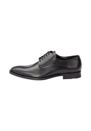Chaussure habillée pour homme en cuir noir avec lacets, bout pointu et petit talon, vue de profil sur fond blanc.