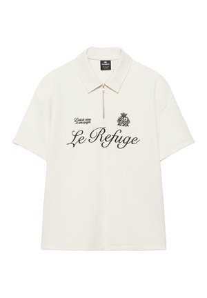 Biała koszulka polo z krótkim rękawem i zamkiem błyskawicznym, czarny napis "Le Refuge", mała tarcza i fraza "L'art de vivre à son apogée" z przodu.