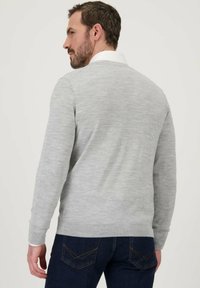 Grijze gebreide trui met een ronde hals en geribde manchetten, gedragen over een witte overhemdenkragen. Heeft een gladde textuur en een slim fit ontwerp.
