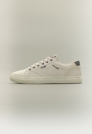 Beżowy niskoprofilowy sneaker z białą podeszwą, beżowymi sznurowadłami i logo „Wrangler” na boku, widoczny z profilu zewnętrznego.