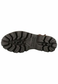 Suela de goma negra de gran resistencia con un patrón de relieve destacado, que presenta surcos profundos para una mejor tracción. Logo visible en la suela.