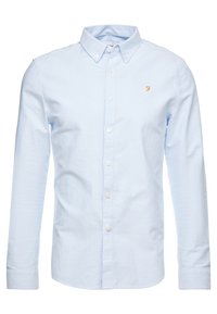 Camisa de botón azul claro hecha de algodón. Presenta un collar clásico y mangas largas, adornada con un pequeño logo amarillo en el pecho.