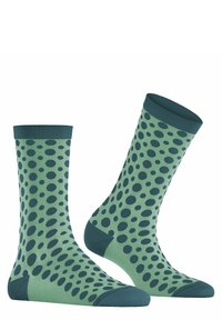 Grüne Socken mit einem gepunkteten Muster in einem dunkleren Grünton, aus einem glatten Material gefertigt, mit einem kontrastierenden gerippten Bündchen und Fußspitze.