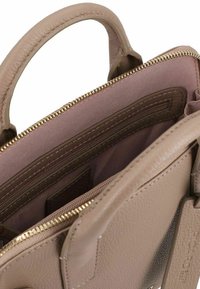 Borsa a tracolla in pelle beige con una finitura testurizzata. Presenta una cerniera dorata, tasche interne e una morbida fodera in tessuto. Due manici robusti.
