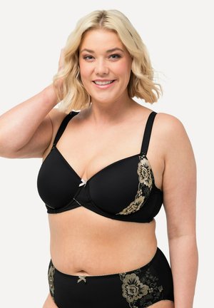 Zwarte bh en bijpassende slipjes met gouden bloemen kant accenten. De bh heeft een beugels en een klein strikje in het midden van de brug.