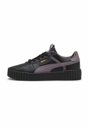 Zapatilla baja negra y morada con suela texturizada, puntera perforada y logo de Puma en el lateral y en la lengüeta.