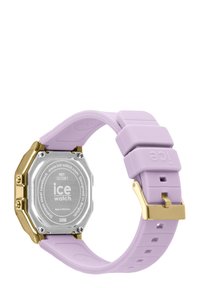 Montre à bracelet en silicone lavande avec un boîtier octagonal en acier inoxydable argenté et des finitions dorées. Équipée d'une fermeture sécurisée et d'une résistance à l'eau.