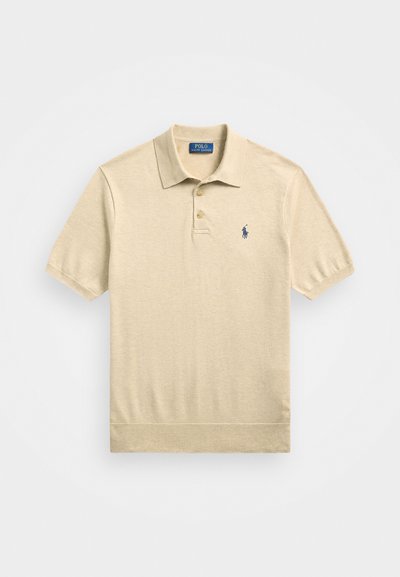 Μπεζ πόλο μπλούζα κατασκευασμένη από μαλακό ύφασμα, με ύφασμα διπλού κουμπιού, κοντά μανίκια και ναυτικό λογότυπο στο αριστερό στήθος.