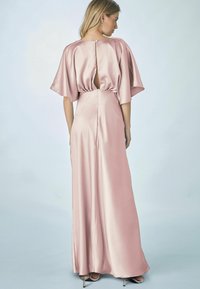 Lång rosa satängklänning med korta, svävande ärmar. Utrustad med ett nyckelhål i ryggen och en golvlång, flödande design. Slät textur.
