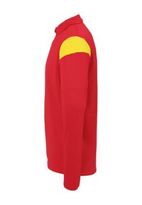 Rød langærmet skjorte med en gul accent på højre skulder. Har en krave og en glat tekstur. Forstærkede syninger er synlige.