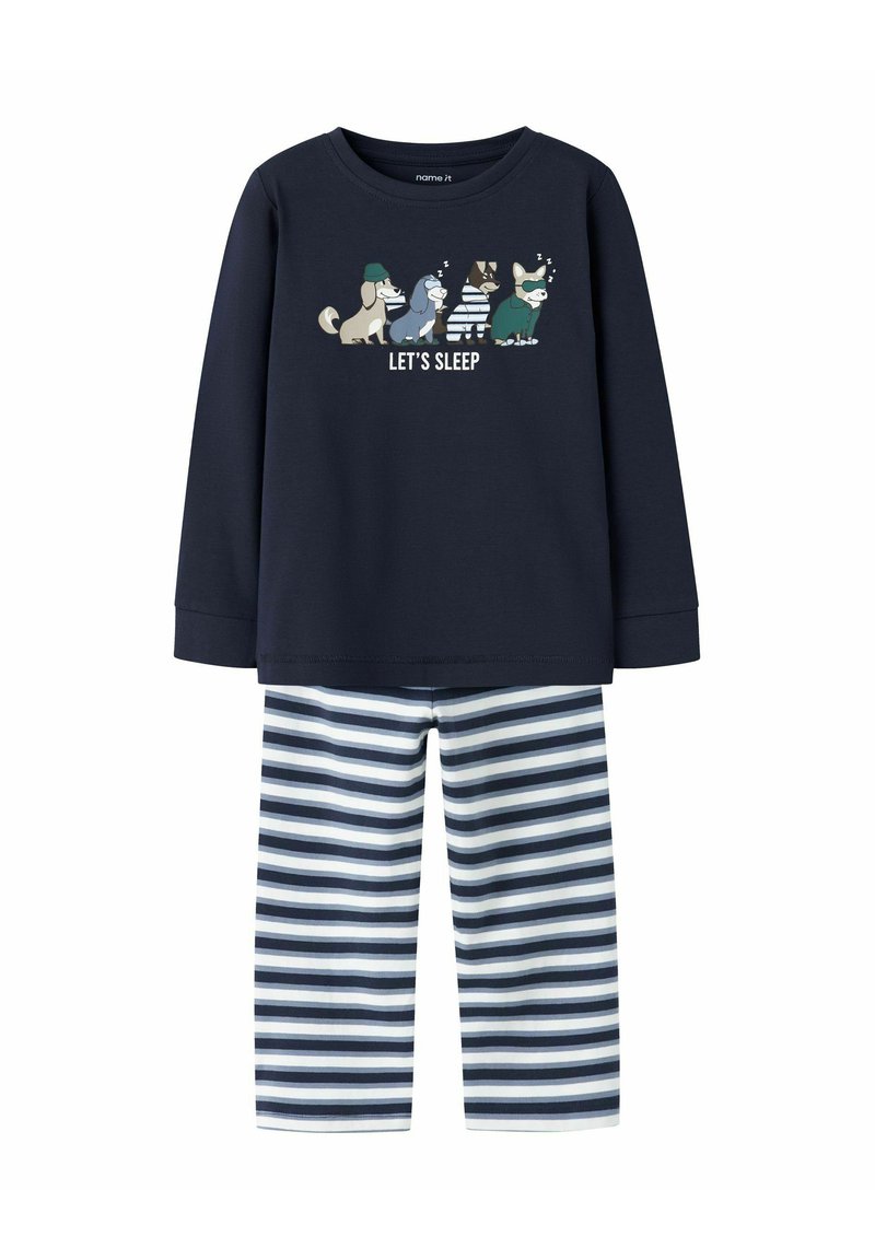 Tumesinise pikkade varrukatega pidžaama ülemine osa, millel on "LASTE MAGADA" graafika ja koomiksite loomad, koos tumesiniste ja valgete triibuliste pükstega. Pehme kangastekstuuri.