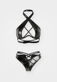 Črn lateks bikini komplet z zgornjim delom na vezanje, ki ima prečno pritrjene naramnice in zlato okrasje, ter ujemajočimi hlačkami z visokim pasom in podobnimi podrobnostmi.