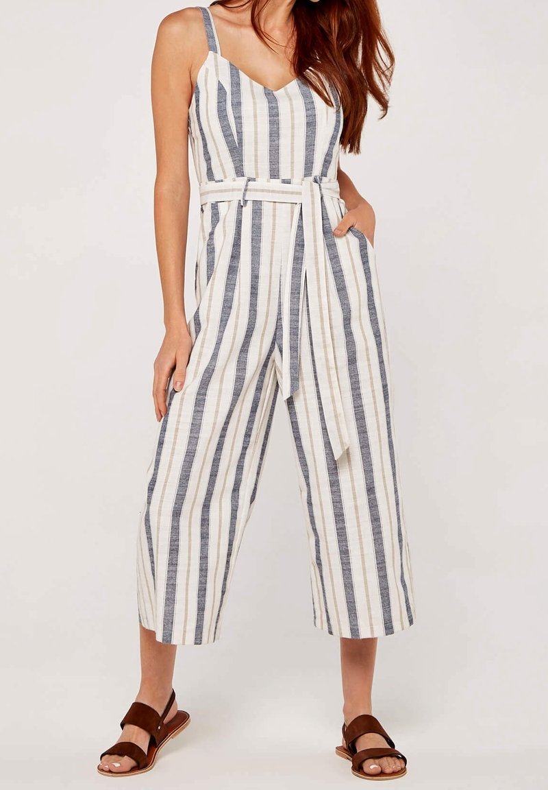 Combinaison à rayures en crème, marine et beige ; dotée d'une taille ceinturée, de jambes larges et de bretelles. Le tissu semble léger et texturé.