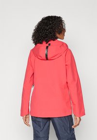 Rote wasserdichte Jacke mit Kapuze, ausgestattet mit einem schwarzen vertikalen Streifen auf der Rückseite, langen Ärmeln und einem lockeren Schnitt.