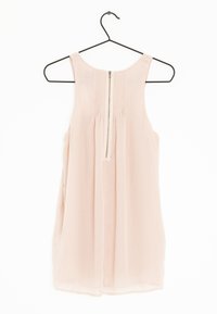 Jasnoróżowa bezrękawnikowa bluzka wykonana z przejrzystej tkaniny, z zamkiem błyskawicznym z przodu i detalem pintuck przy dekolcie. Wisi na czarnym haczyku.