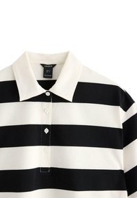 Sort-hvid stribet polo T-shirt med krave, der har en knaplukning og blød bomuldsstruktur. Etiket synlig inde i kraven.