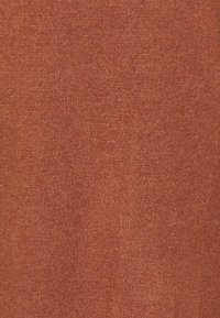 Tessuto di maglia terracotta, morbido al tatto, con una trama fine e leggermente melangiata. Colore uniforme con variazioni minime.