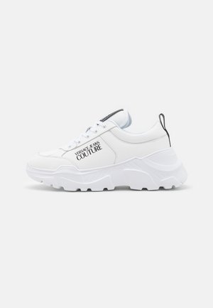 Sneakers blancs avec des panneaux texturés, semelle épaisse et détails de marque. Comprend des lacets et une languette au talon pour un enfilage facile.