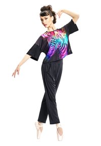 Čierny crop top s živým zebrovým vzorom a odvážnym textom, kombinovaný s čiernymi, zúženými nohavicami. Modelka má na sebe svetloružové baletky.