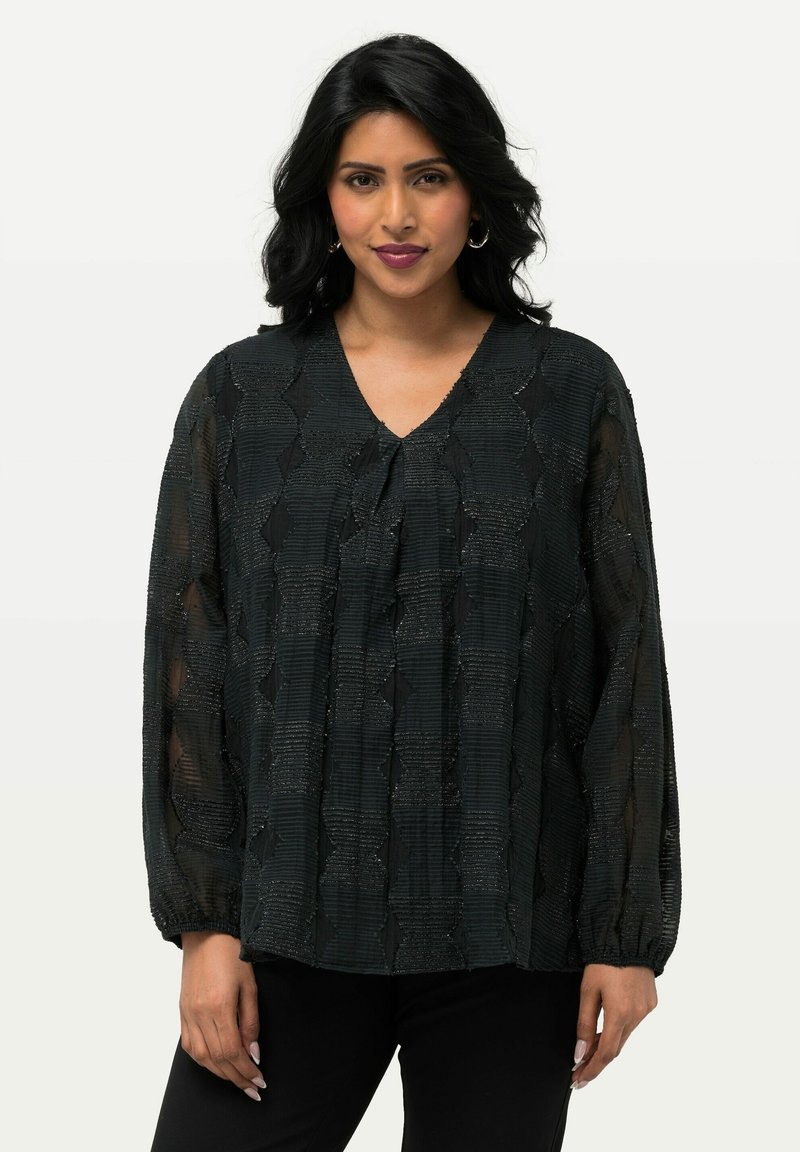 Blusa nera in tessuto testurizzato con scollatura a V, maniche lunghe a sbuffo e un motivo intrecciato con una leggera lucentezza. Tessuto morbido con dettagli arricciati sulle maniche.