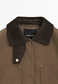 Braune Jacke mit einem strukturierten Cordkragen, Metall-Druckknöpfen und einer Fronttasche. Ein Etikett im Kragen ist sichtbar und trägt die Aufschrift "Massimo Dutti."