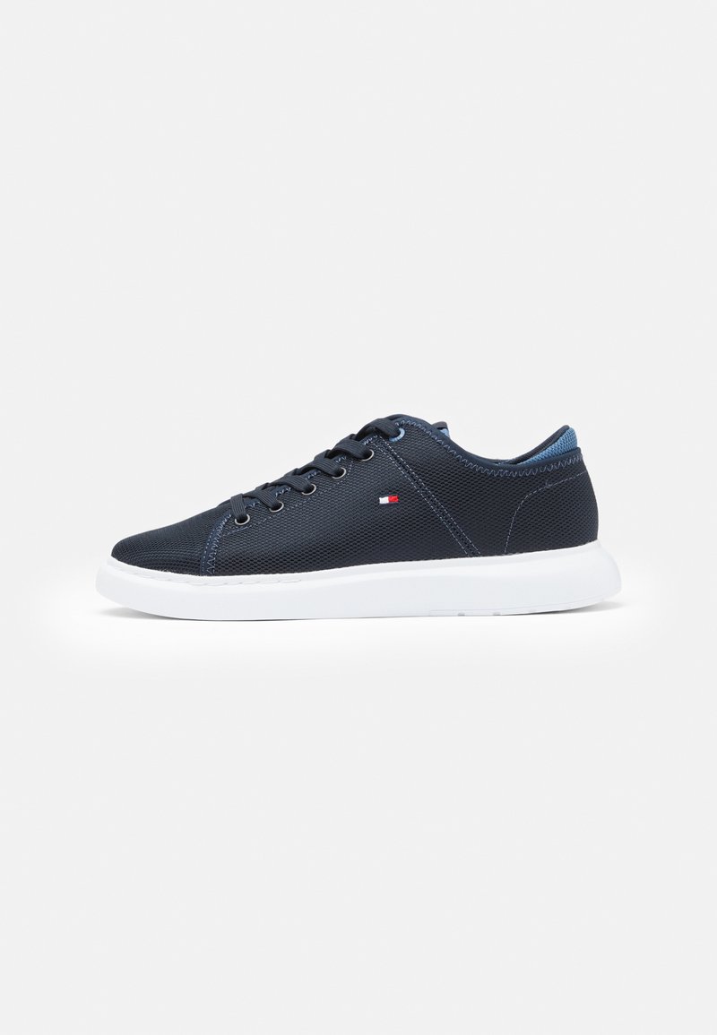 Sneakers in tela blu con suola in gomma bianca, punta rotonda e chiusura con lacci; presentano un logo ricamato sul lato e accenti a contrasto.