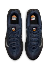 Scarpe sportive blu navy con tomaia in rete, motivo testurizzato, suola in gomma nera, lacci e logo Nike bianco prominente.