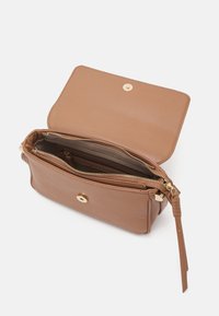 Brun läderhandväska med klaffstängning och guldiga detaljer. Har flera fack, inklusive en med dragkedja. Slät textur.