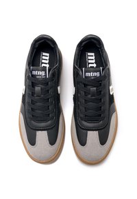 Zapatillas sintéticas en negro y gris con parte superior texturizada, cordones negros, detalles de logotipo blanco y suelas de goma natural.