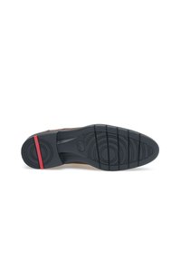 Chaussure en cuir marron avec une semelle en caoutchouc noir texturé, ornée de motifs circulaires et d'une bande d'accent rouge. Construction robuste, design formel.
