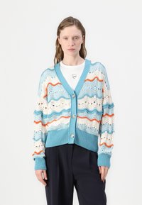Lett strikket cardigan med bølgete mønstre i blått, hvitt og oransje. Knapplukking med ribbestrikkede mansjetter og kant.