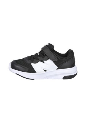 Zapatilla deportiva New Balance en blanco y negro con cierre de velcro y cordones, parte superior de malla transpirable y suela blanca acolchada.