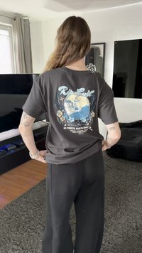 Μαύρο βαμβακερό T-shirt με πολύχρωμο γραφικό που απεικονίζει μια γη και λουλούδια, με το κείμενο «Rip Curl» και τη λεπτομέρεια «Ultimate Surfing Co.» στην πίσω πλευρά.