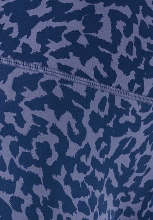 Nahaufnahme von marineblauem und grauem Tierdruckstoff mit sichtbarer horizontaler Naht und geripptem Stichdetail.