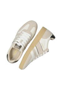 Scarpe sportive beige e bianche realizzate in suede e pelle, con un design retrò, strisce nere a contrasto e una suola in gomma testurizzata.