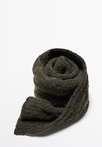 Écharpe en tricot vert foncé, roulée en forme de rose, présentant un tissu texturé avec une apparence douce et duveteuse ainsi qu'un bord irrégulier.