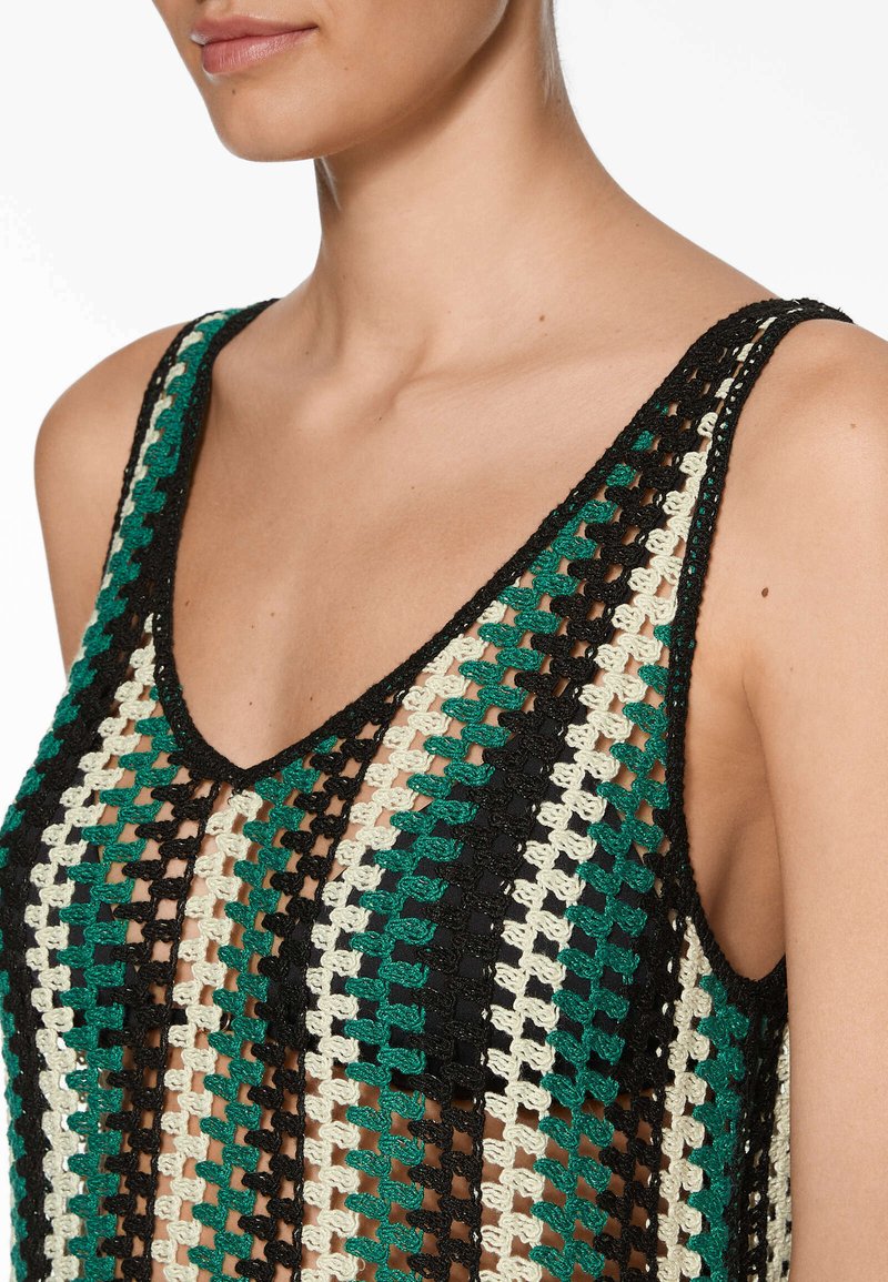 Top de punto sin mangas en negro, verde y crema con escote en V. Presenta un patrón de tejido holgado y abierto con tirantes finos.