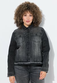 Musta farkkutakki, jossa on kaulus, napitus edessä ja kaksi rintataskua. Takkissa on haalistunut viimeistely ja lyhyempi malli.