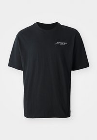 Black cotton t-shirt with a crew neck, short sleeves, relaxed fit, and white logo text on the left chest area. No patterns or accents.
