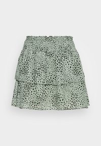 Jupe tiered vert clair avec taille élastique smockée et motif de points noirs irréguliers, présentée sur fond blanc.